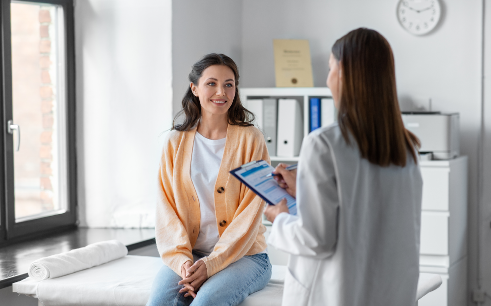 Woman smiles during hormone replacement therapy consultation with her doctor.