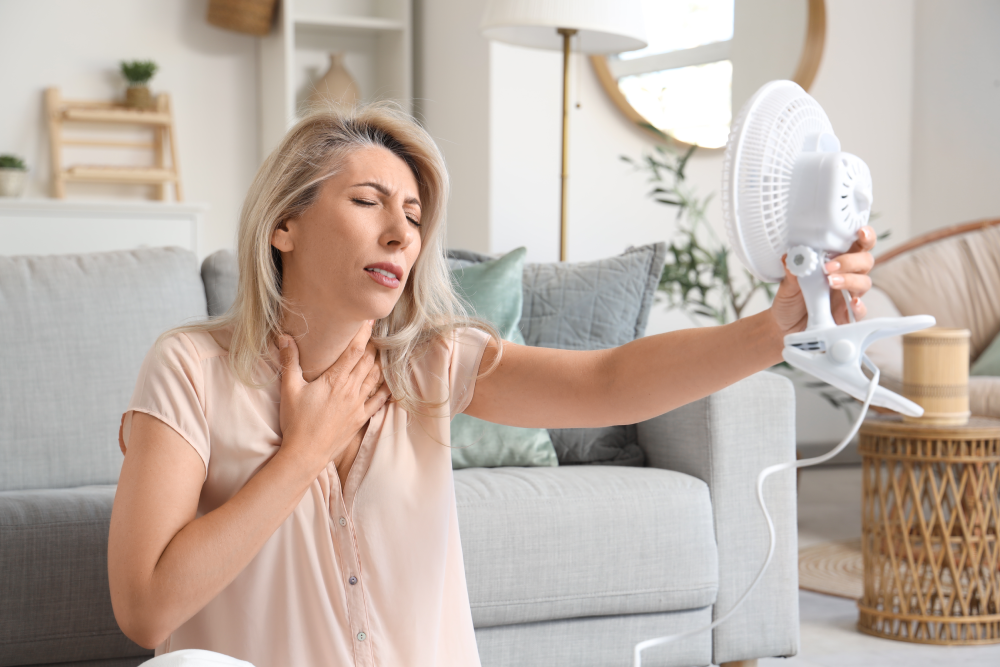 Woman experiencing hot flashes seeks relief through hormone replacement therapy.