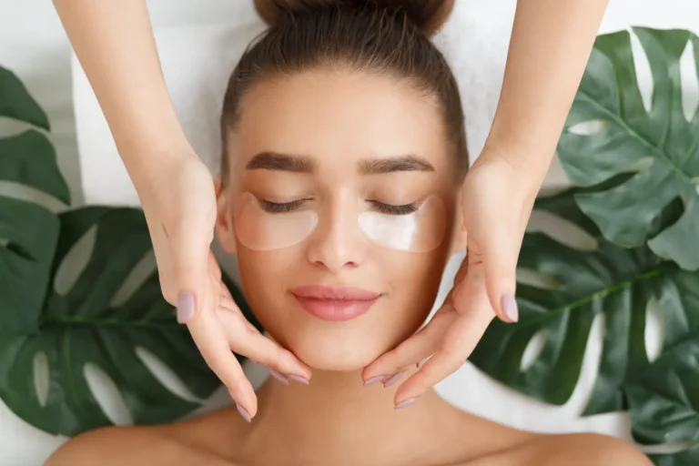 Person with under-eye patches while hands gently frame the face near the jawline.